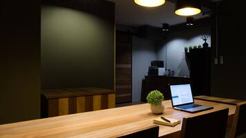 Un comedor moderno con una mesa de madera, una computadora portátil y una planta en maceta.