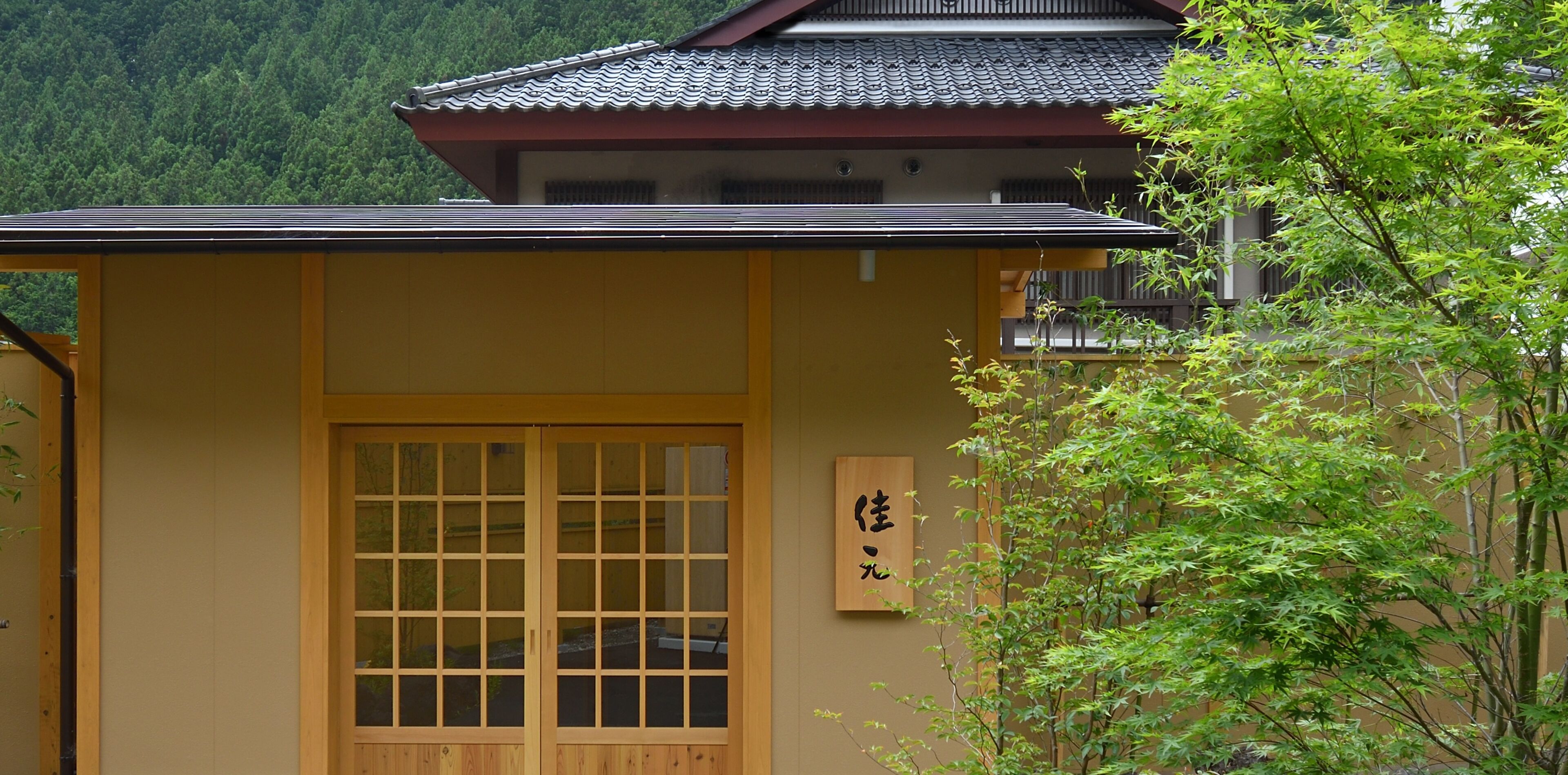 A traditional Japanese building with a wooden sliding door and a sign with Japanese characters.