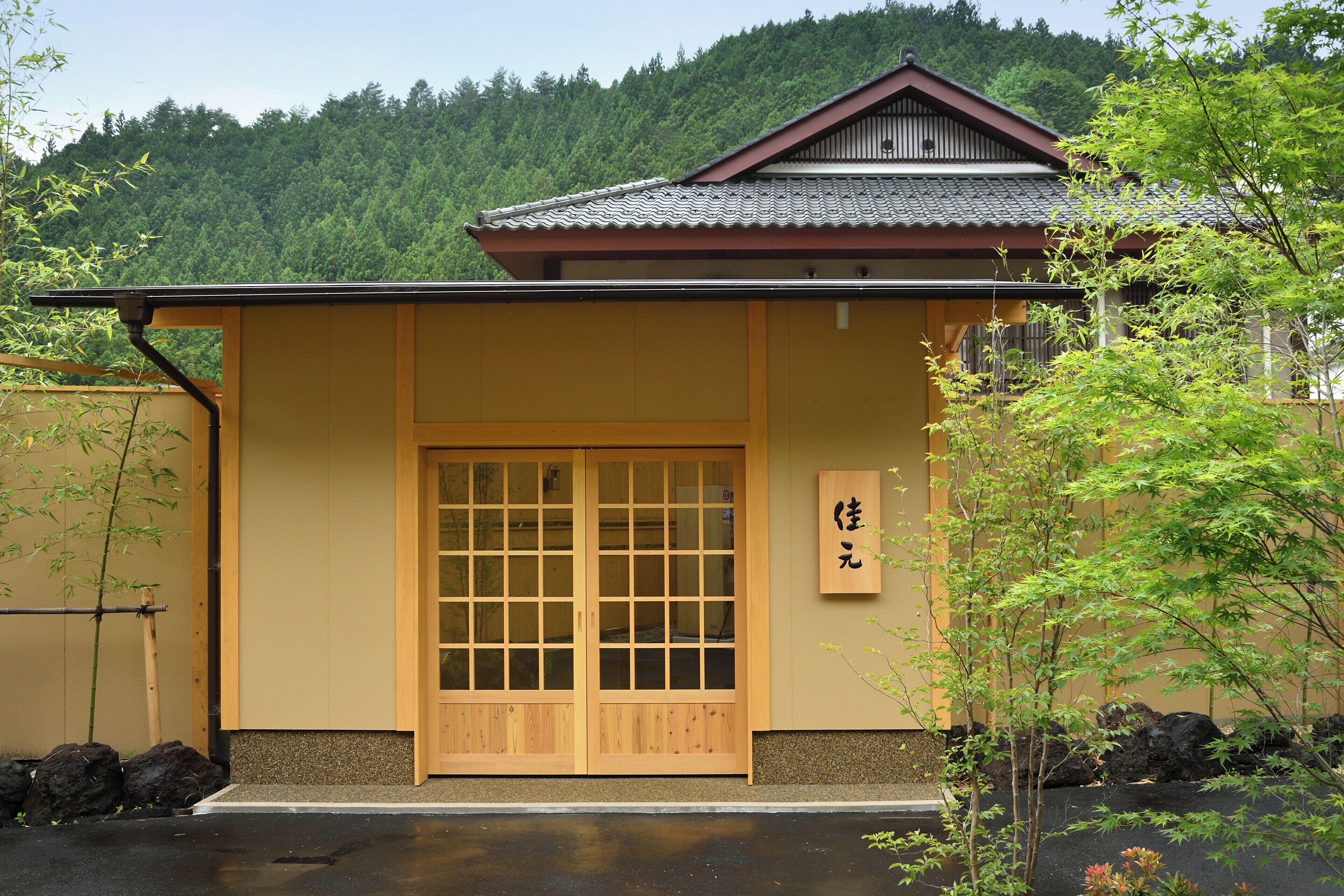 Un edificio tradicional japonés con puerta de madera y un cartel.