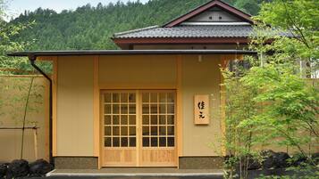 Un edificio tradicional japonés con puerta de madera y un cartel.