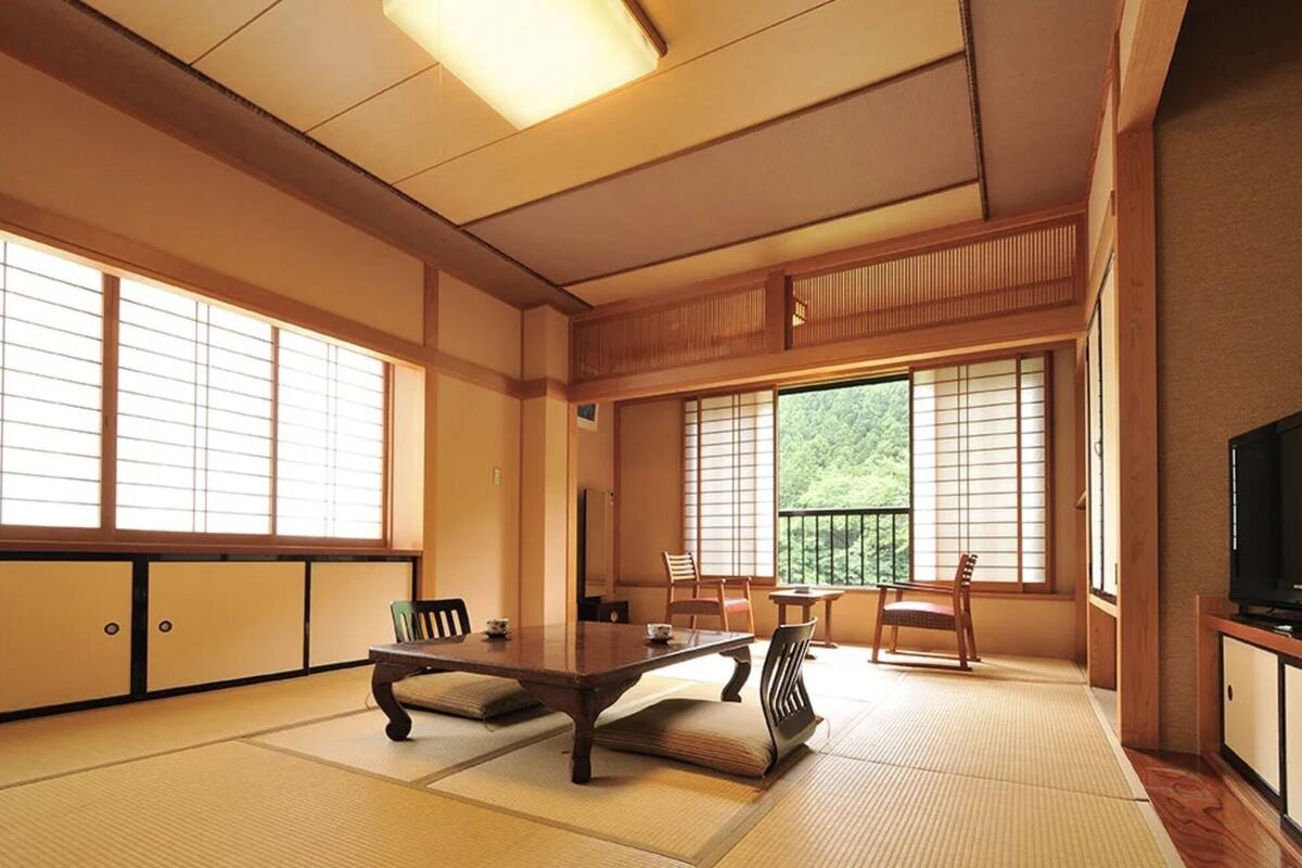 A traditional Japanese room with tatami flooring, a low table, and sliding doors.