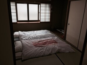 Une petite pièce avec un lit, une fenêtre et une armoire.