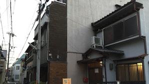 A narrow street with traditional Japanese buildings, a bicycle, and a signboard. - Kyoto Guesthouse Oyado KEI (Kyoto)