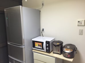 A kitchen with a refrigerator, microwave, toaster, and rice cooker on a countertop. - Kyoto Guesthouse Oyado KEI (Kyoto)