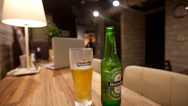 Un tavolo con un boccale di birra e una bottiglia di Heineken.
