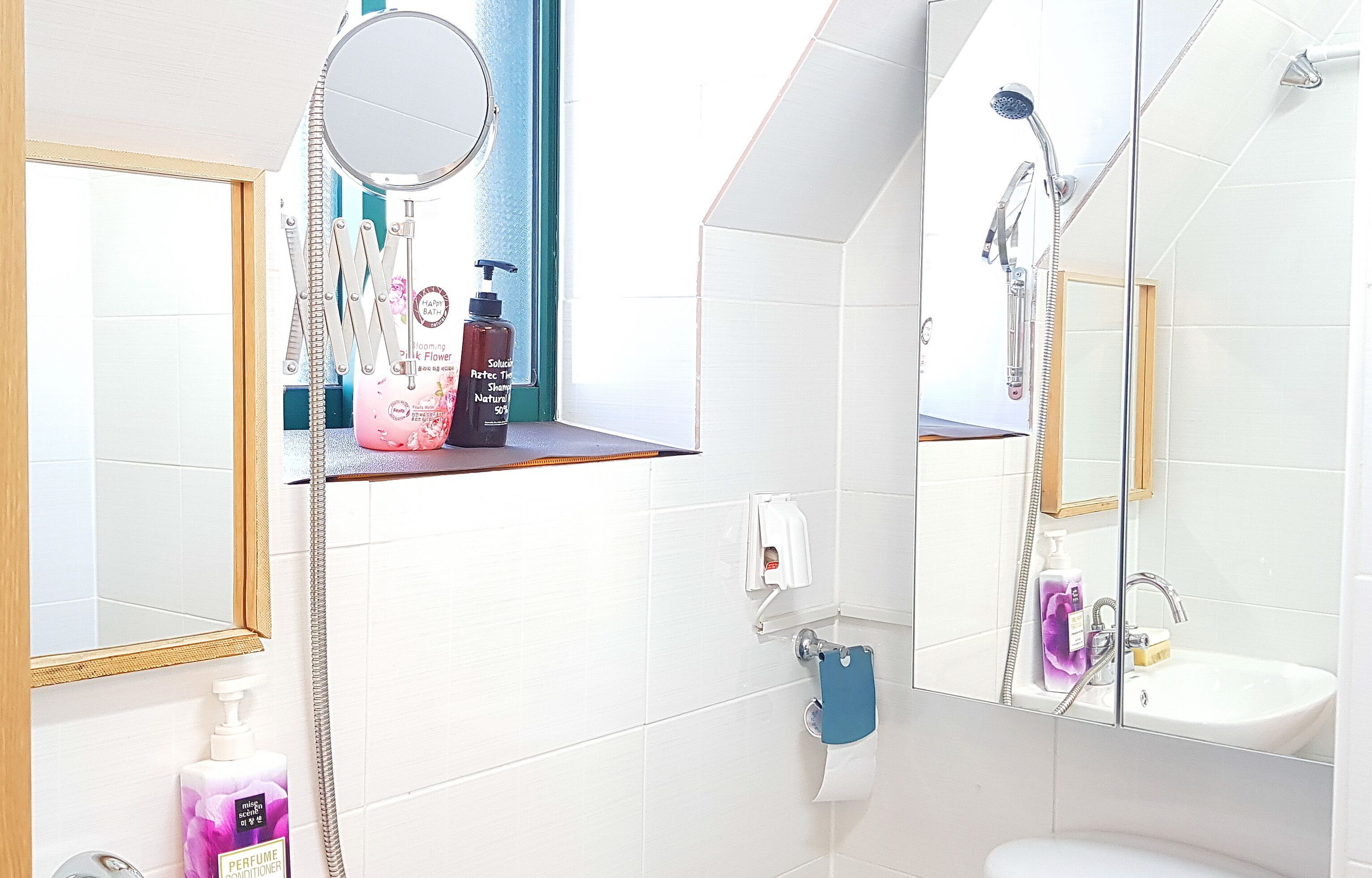 A bathroom with a sink, mirror, and shower.