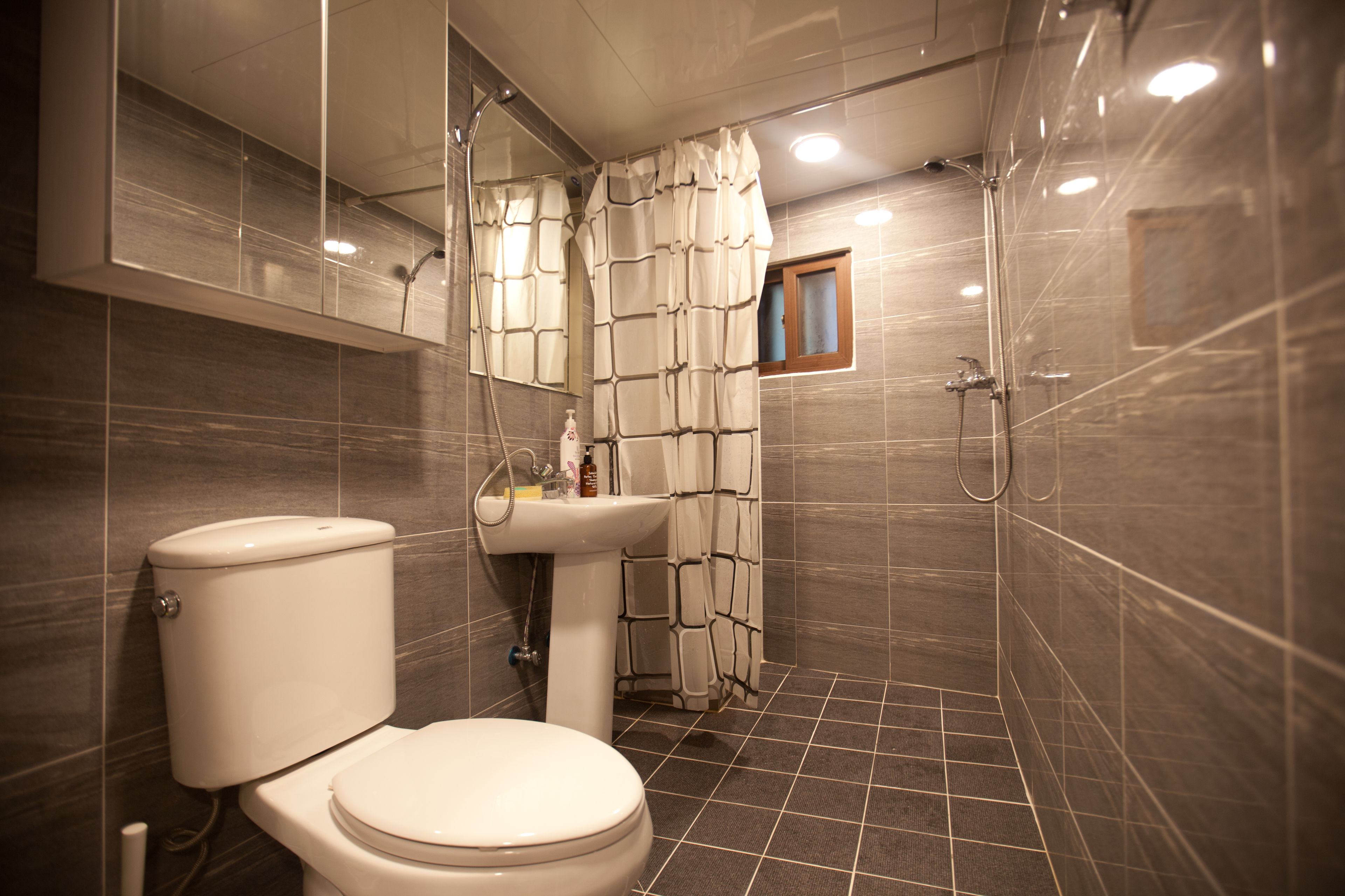 Un baño moderno con inodoro, lavabo y ducha.