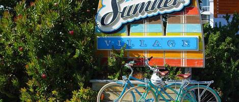 Schild für 'Summer Village', davor ein Fahrrad geparkt.