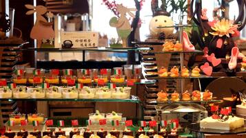 Una presentación de postres con diversos dulces y pasteles, algunos adornados con pequeñas banderas.