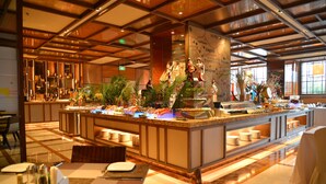 A buffet area with a variety of food items, a map on the wall, and a seating area with tables and chairs. - Sanding New Century Grand Hotel Yiwu (Jinhua)