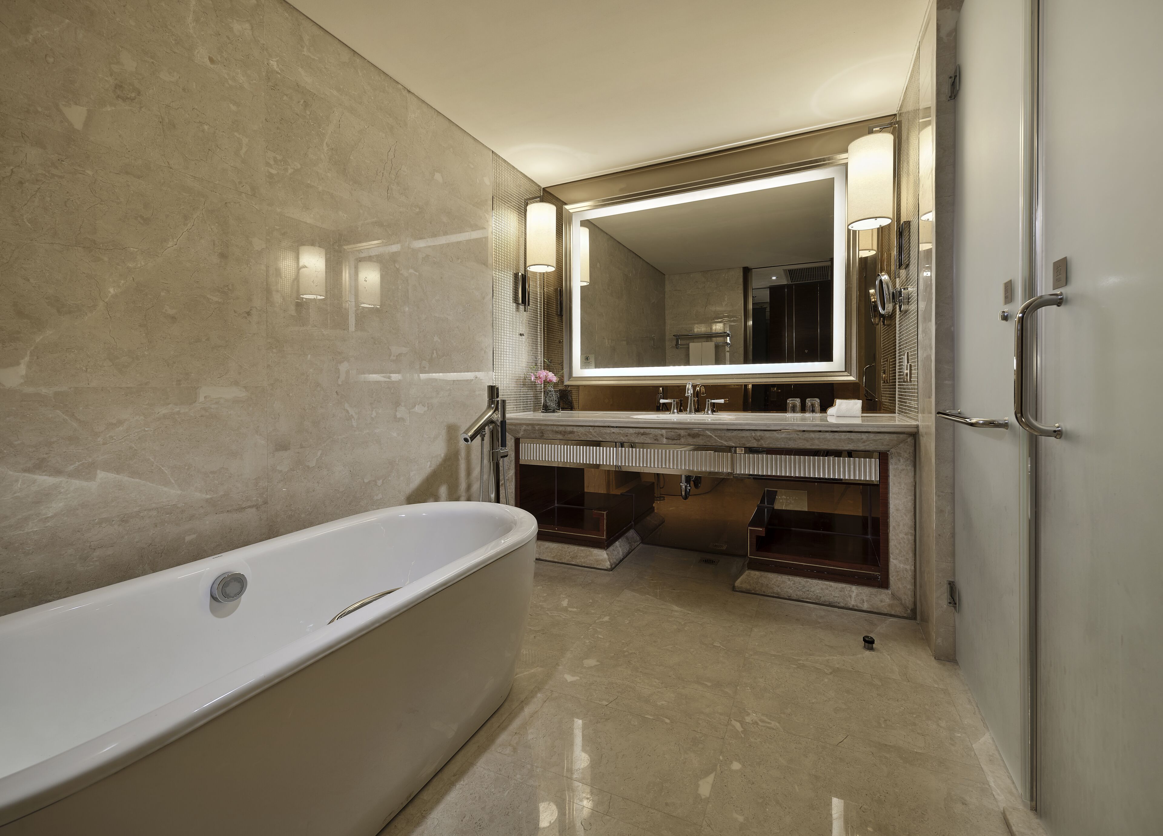 Une salle de bain moderne avec une baignoire sur pieds, un grand miroir et un meuble-lavabo doté d’un évier et d’un porte-serviettes.