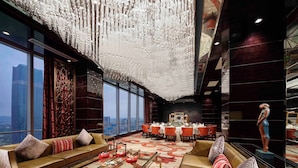 A luxurious hotel lobby with a high ceiling, large windows, and a central dining area. - Sanding New Century Grand Hotel Yiwu (Jinhua)