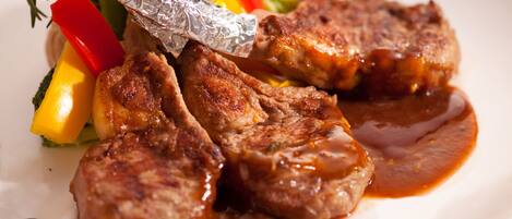 Une assiette de nourriture comprenant de la viande et des légumes grillés.