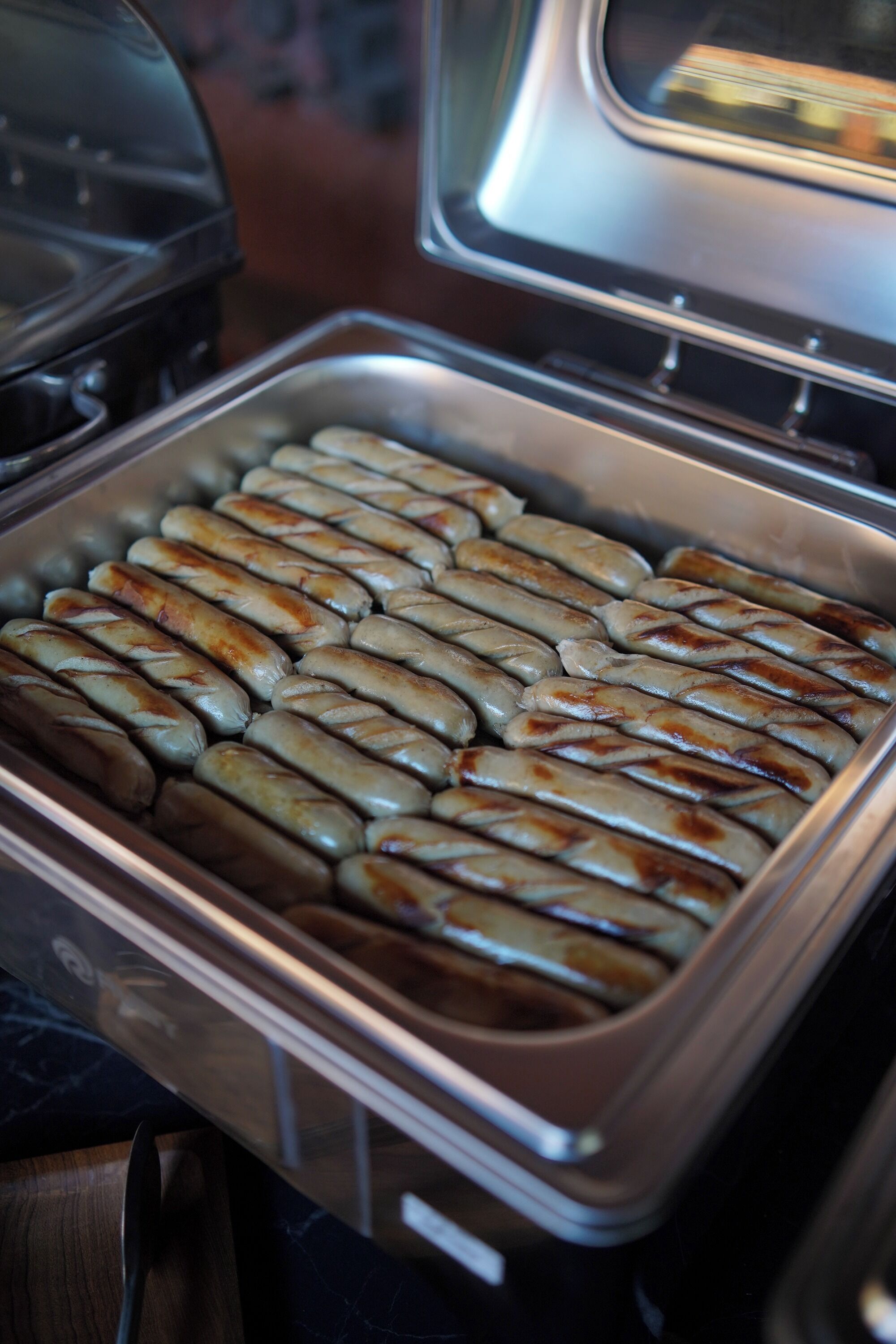 Un buffet proposant une variété de saucisses cuites, présentées sur un plateau.