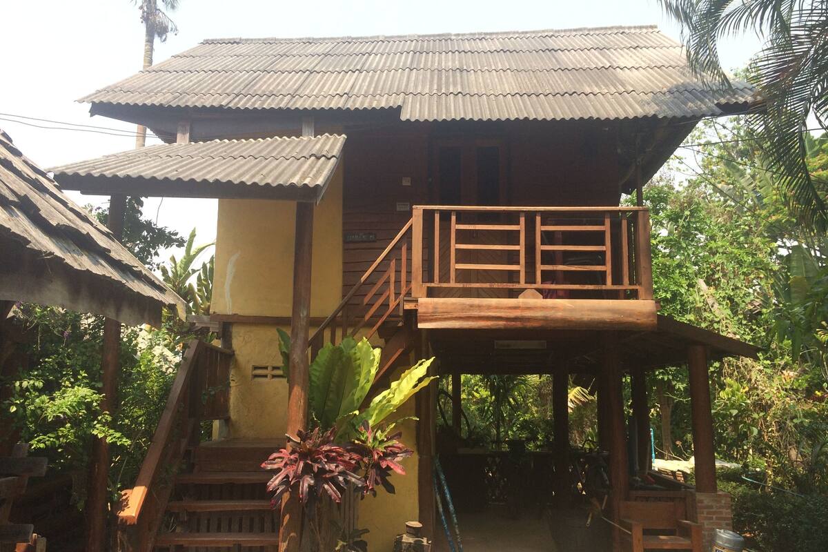 A two-story building with a wooden balcony and stairs leading to the upper level.