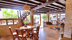 A spacious, open-plan dining area with wooden furniture and a high ceiling. - Huan Kawin Est.58 Lanna Home & Collection - Campus Accommodation (Chiang Rai)
