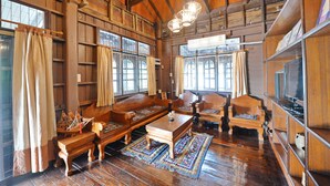 A traditional wooden interior with a high ceiling, wooden furniture, and large windows. - Huan Kawin Est.58 Lanna Home & Collection - Campus Accommodation (Chiang Rai)
