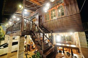 A wooden building with a staircase and multiple windows.