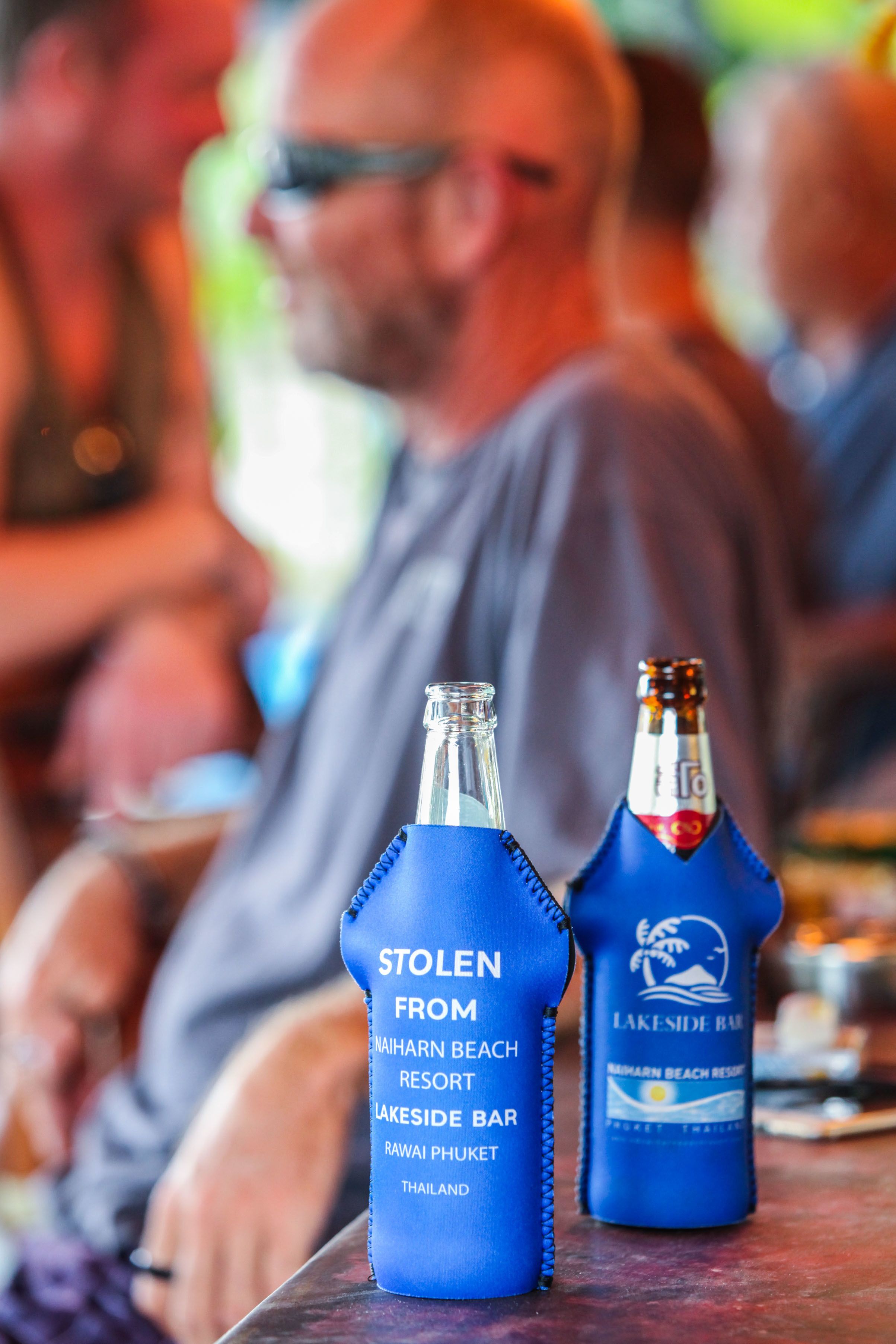 Dos botellas con la etiqueta “Robado del Bar Lakeside del Naiharn Beach Resort” y “Bar Lakeside” sobre una mesa.