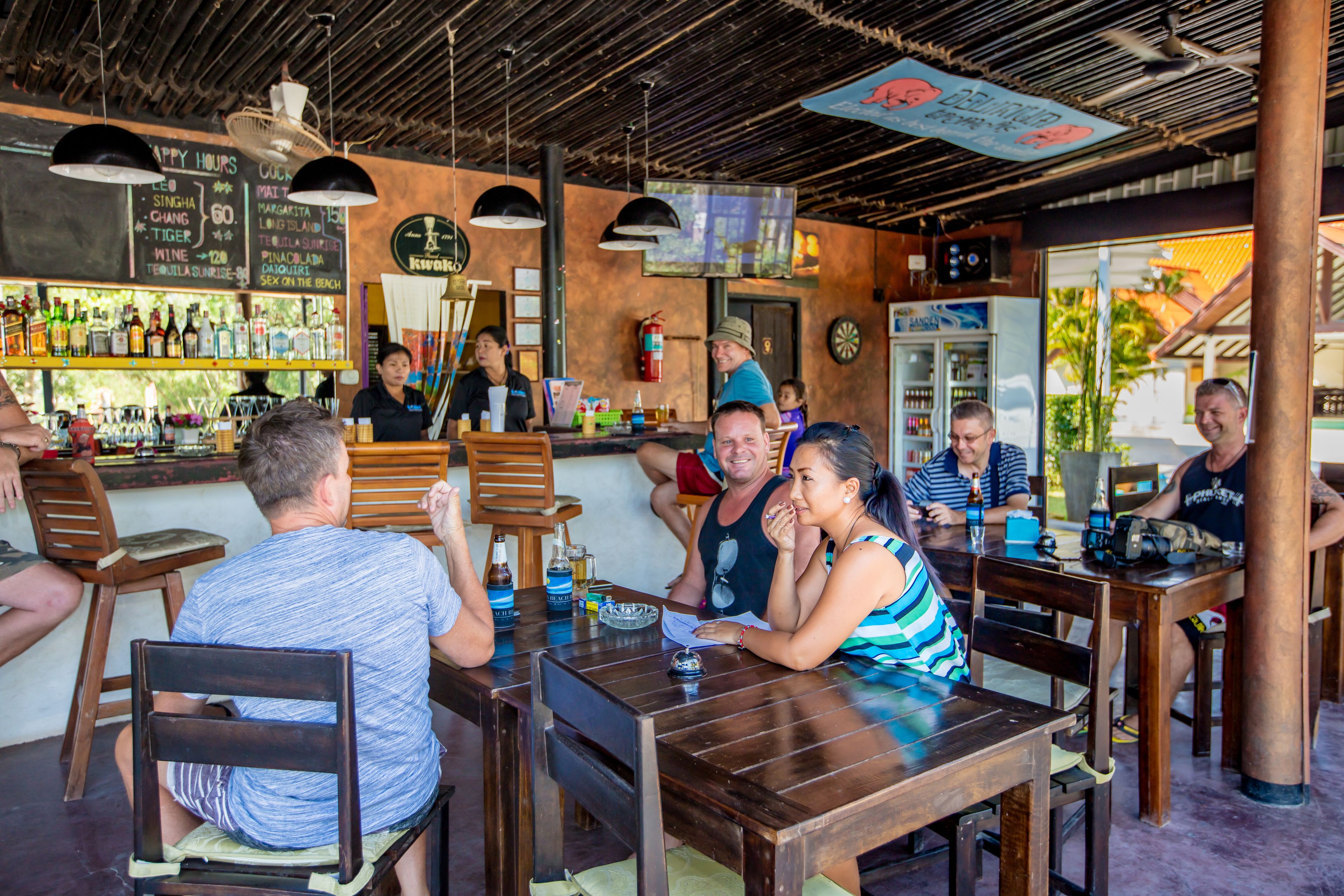 Um bar com móveis de madeira e um cardápio em lousa.