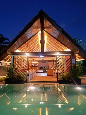 A building with a wooden roof and a pool in front. - Naiharn Beach Resort (Rawai)