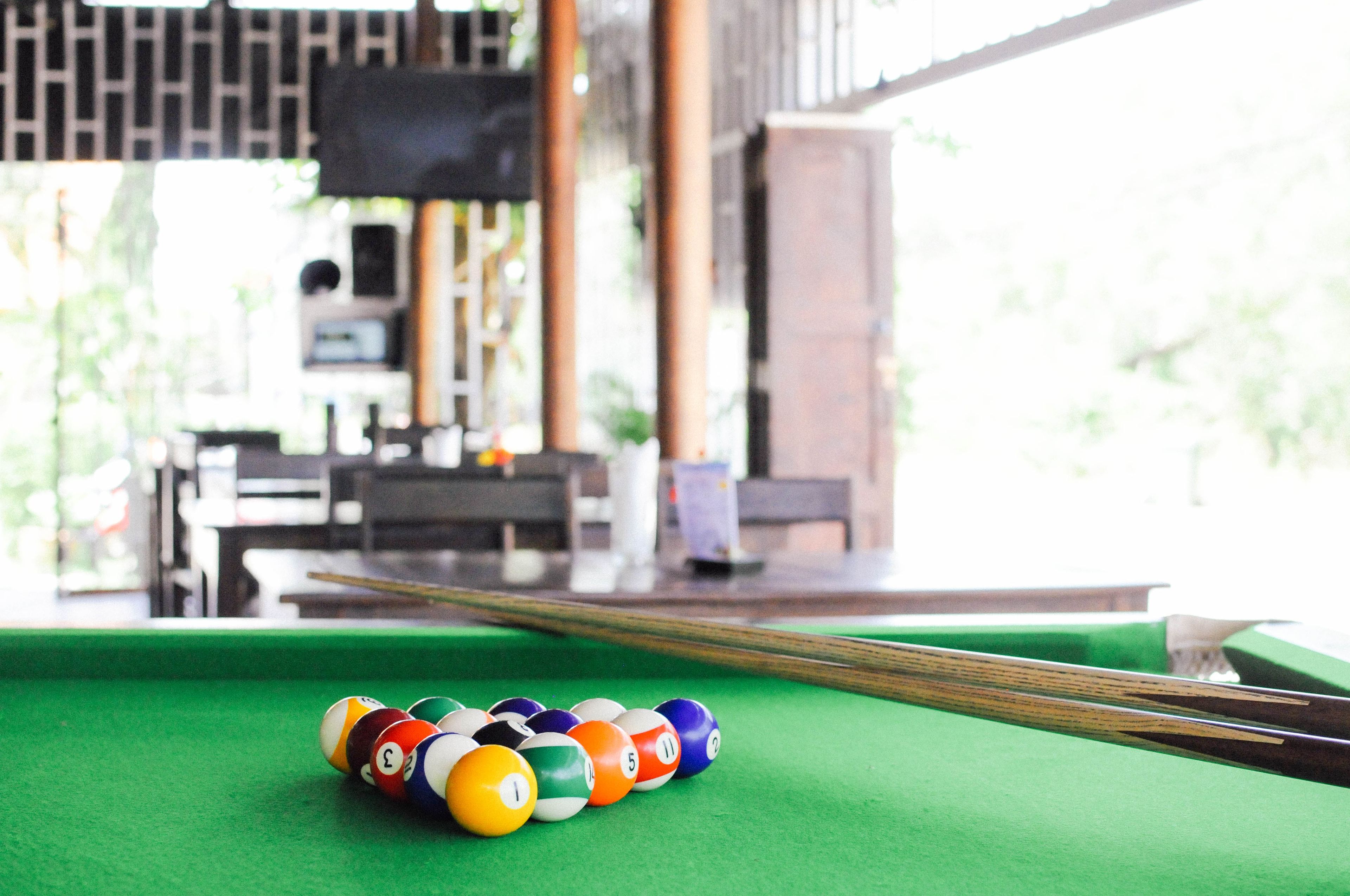 A pool table with a green felt surface and a set of numbered billiard balls.