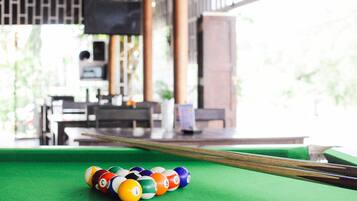 A pool table with a green felt surface and a set of numbered billiard balls.
