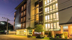 A modern hotel with multiple floors, large windows, and a well-lit facade. - Chonlada Place (Chiang Mai)