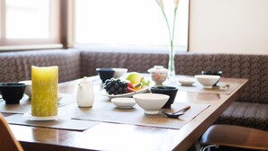 A traditional Japanese tea setting with a table, tea utensils, and a candle. - Toshokan 2 (Kutchan)