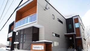 A modern two-story building with a sign reading "Toshokan." - Toshokan 2 (Kutchan)