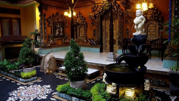 An ornate interior with intricate woodwork, a fountain, and a statue. - Pondok Denayu Homestay (Kuta)