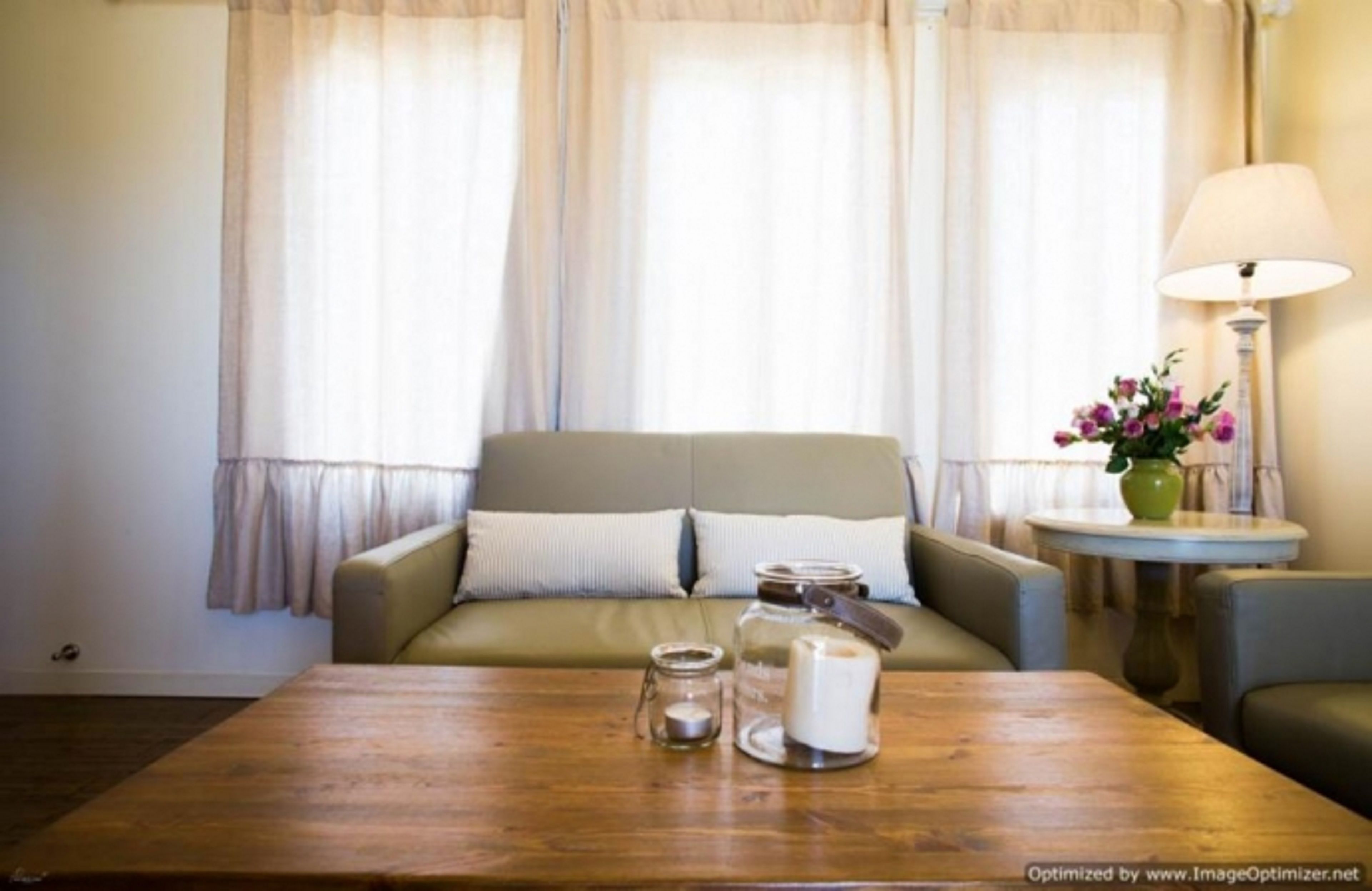 A cozy living room with a sofa, a wooden coffee table, and a lamp.