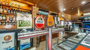Un bar avec différents robinets à bière et des étagères remplies de bouteilles.
