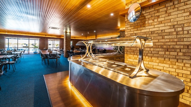 Un restaurant doté d’un buffet, d’un plafond en bois, de murs en briques et de grandes fenêtres.