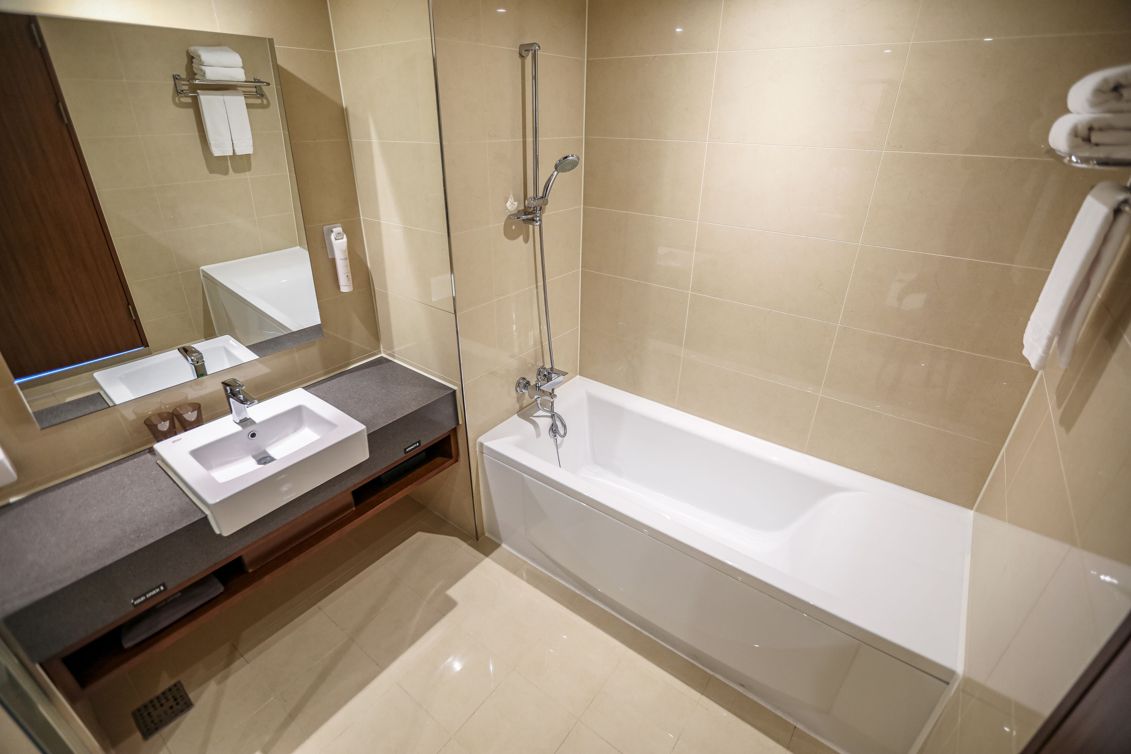 Un baño moderno con una bañera grande, un tocador con lavabo y un espejo.