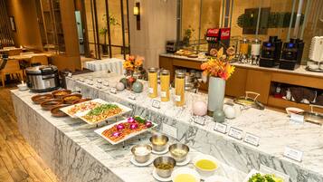 A buffet with various food items and condiments.