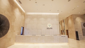 A hotel reception area with a modern design, featuring a reception desk labeled "FRONT DESK" and a logo for "HOTEL LACKY SWANG-YANG". - Hotel Lacky Gwangyang (Gwangyang)