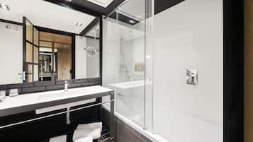 Un bagno moderno con doccia vetrata, uno specchio grande e una palette colori bianco e nero.