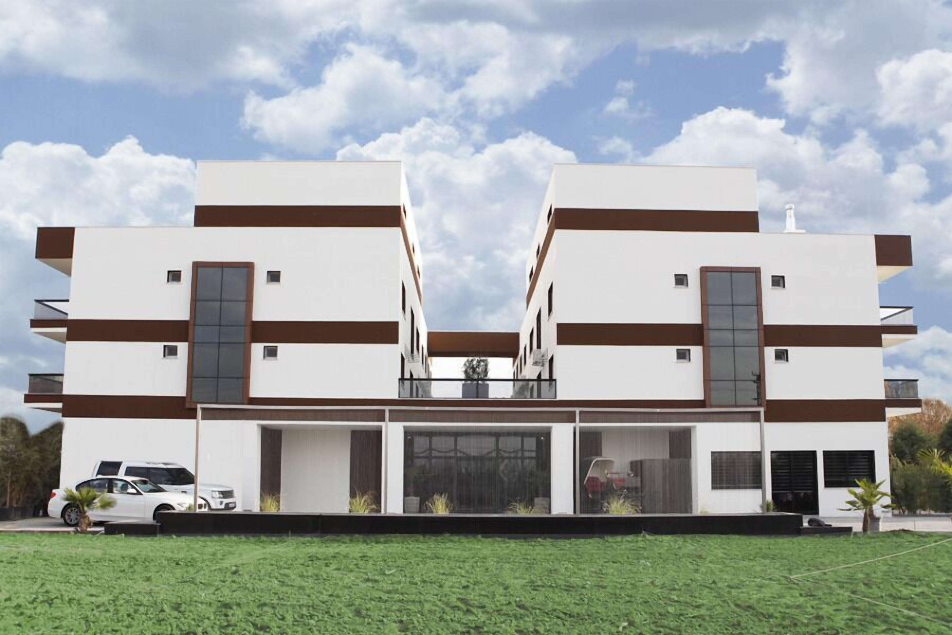 Um edifício moderno de dois andares com fachada simétrica, janelas amplas e telhado plano.