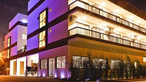 Un hotel de varios pisos con diseño moderno, que cuenta con balcones y ventanas amplias.