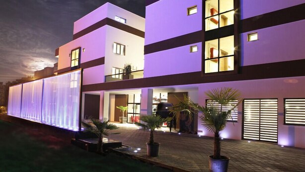 Un edificio moderno con techo plano, ventanas amplias y una entrada bien iluminada.