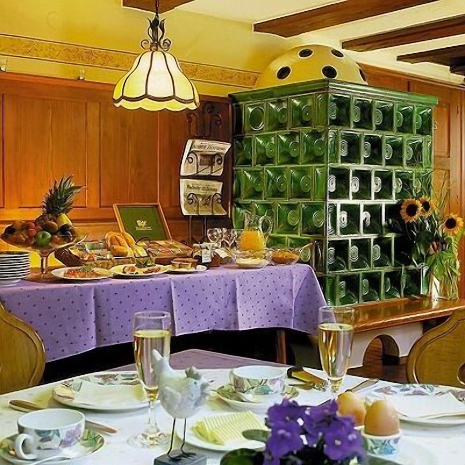A dining area with a table set for a meal, a decorative bird figurine, and a green cabinet with glass doors.