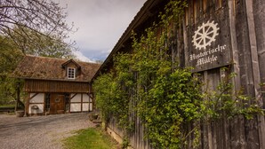 Un bâtiment en bois avec une enseigne indiquant « Historische Mühle » et un symbole de roue.