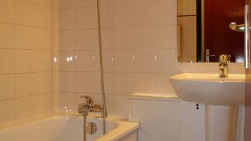 Une salle de bain avec une baignoire, un lavabo et un miroir.