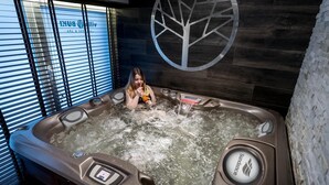 Ein Whirlpool mit Bedienfeld, ein Logo an der Wand und ein Fenster mit Jalousien.