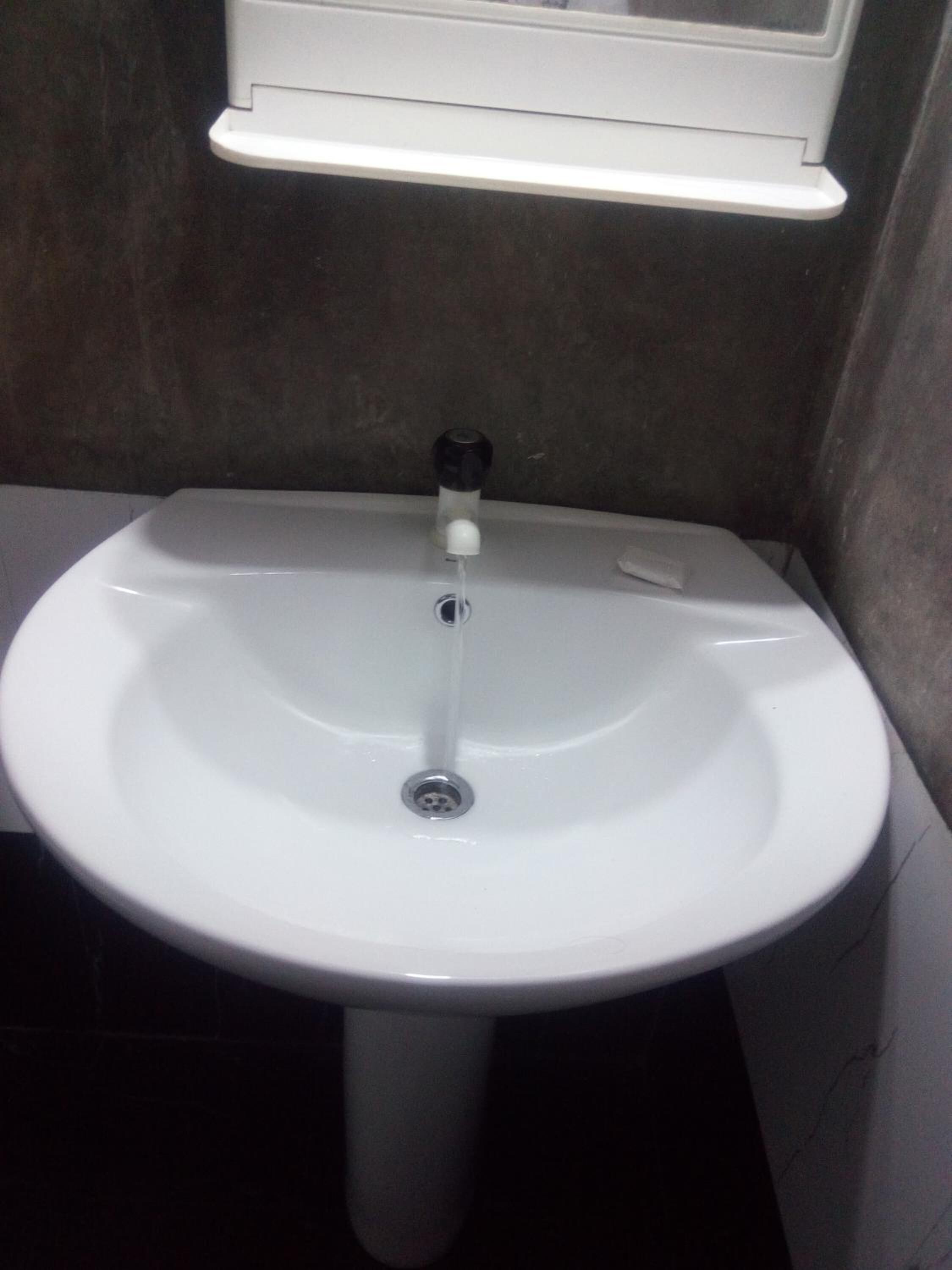 A white bathroom sink with a faucet and a mirror above it.