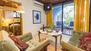 A cozy living room with a sofa, armchair, and a table with a vase and flowers. - Havaya Ba Nof (Rosh Pinna)