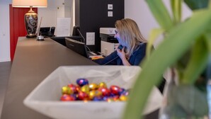 Una recepción con una computadora, un teléfono y una lámpara decorativa.