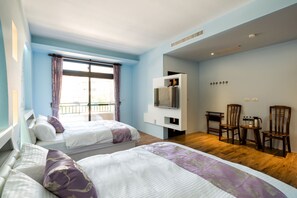 A hotel room with two beds, a TV, a small table with chairs, and a window with curtains. - Fun Going B&B (Hualien City)
