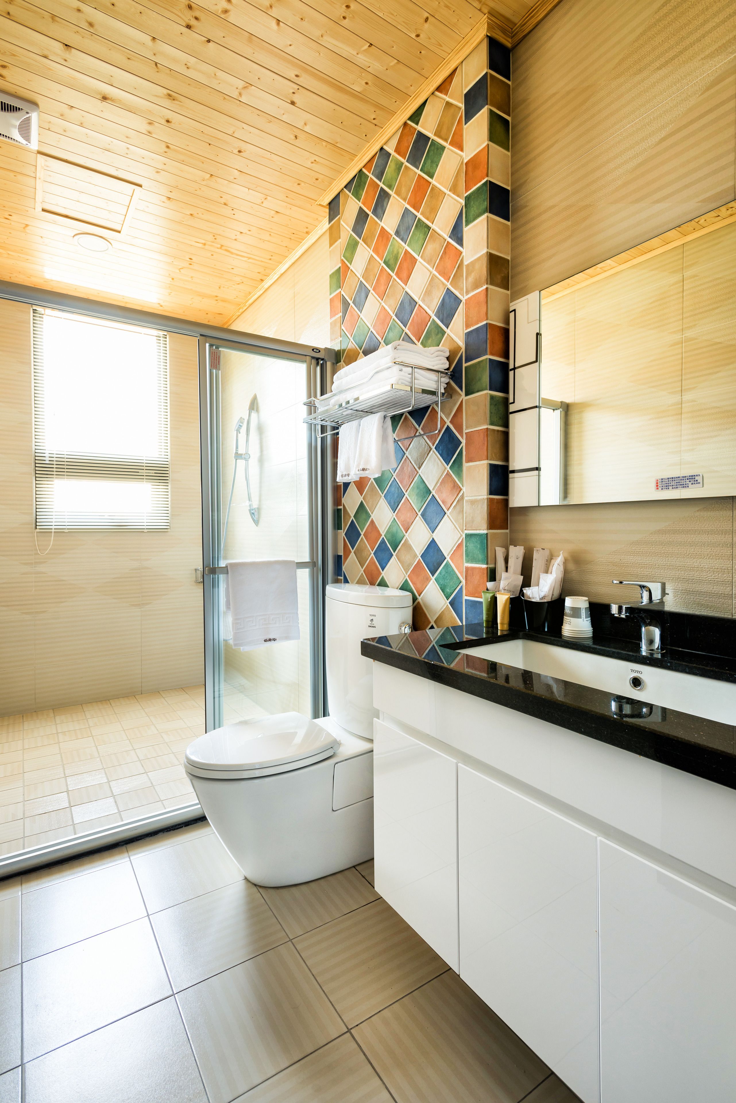 A modern bathroom with a shower, toilet, and sink.